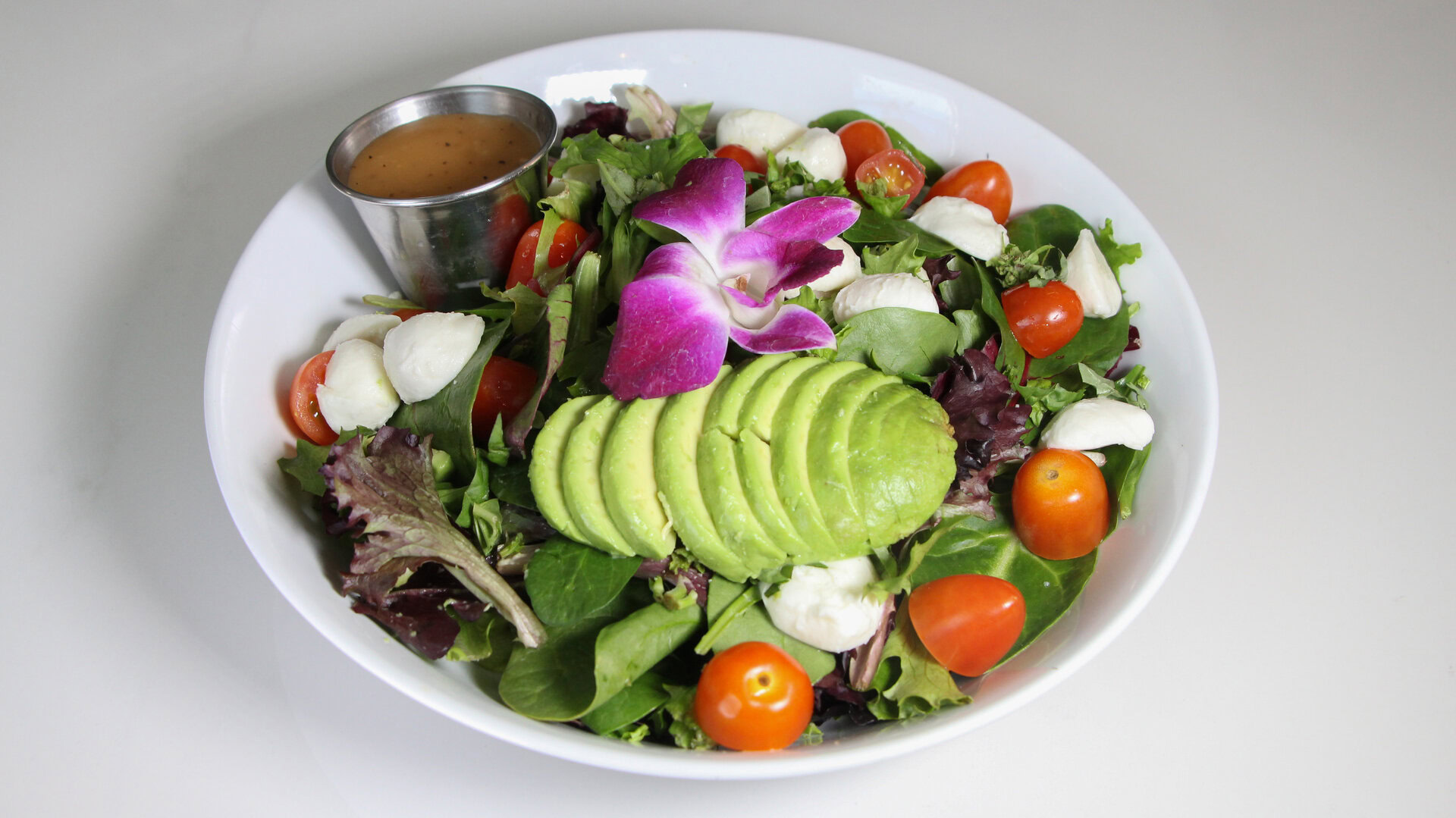 fresh avocado salad bowl with mozzarella and tomatoes