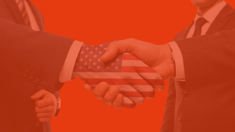 american business handshake with flag overlay