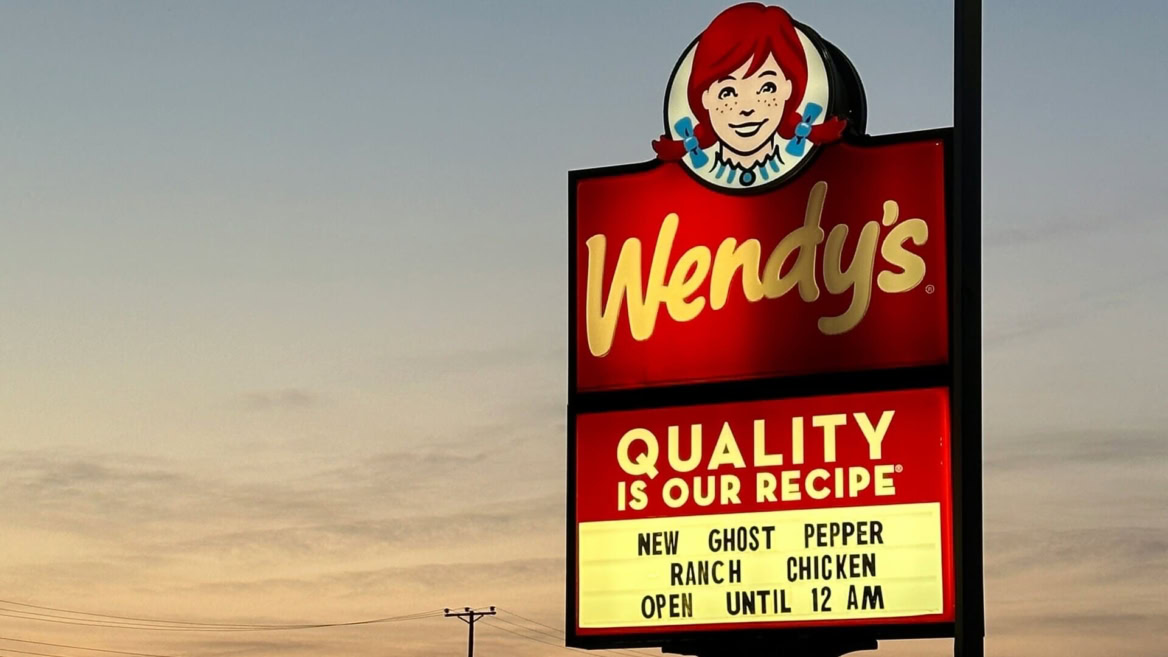 insegna luminosa wendys con mascotte al tramonto
