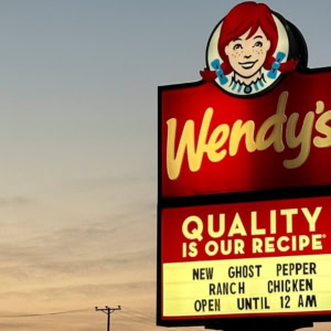 insegna luminosa wendys con mascotte al tramonto