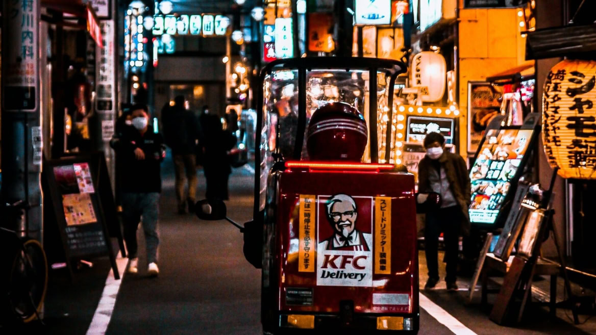 scooter kfc rosso per consegne in vicolo notturno
