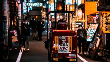 scooter kfc rosso per consegne in vicolo notturno