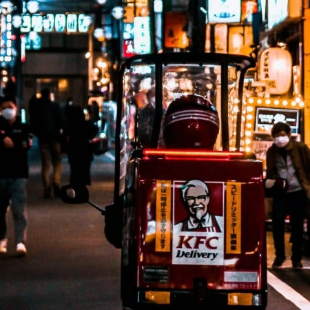 scooter kfc rosso per consegne in vicolo notturno