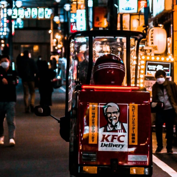 scooter kfc rosso per consegne in vicolo notturno