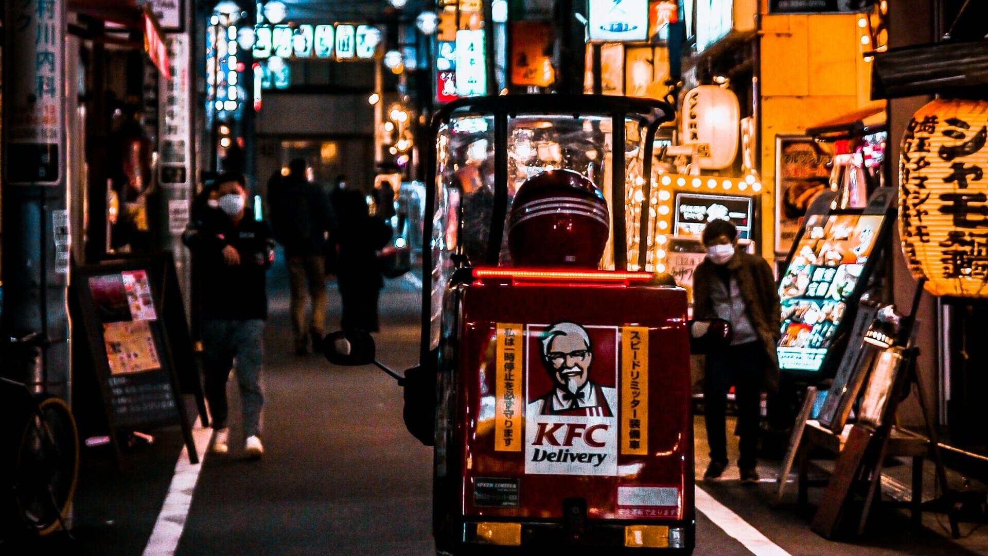 scooter kfc rosso per consegne in vicolo notturno