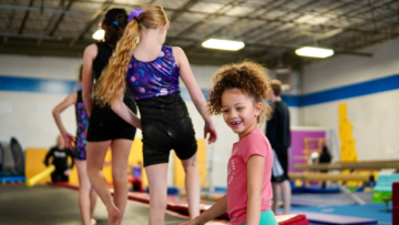 smiling girls practicing gymnastics indoors