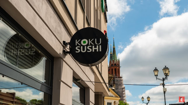 szyld koku sushi z wieżą kościelną w tle