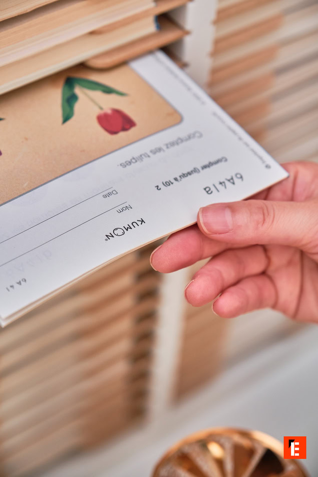 main insérant carte kumon tulipe dans casier en bois