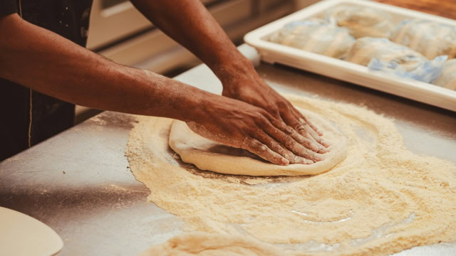 mains pétrissant une pâte à pizza artisanale