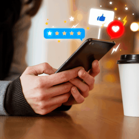 manos con móvil en café y redes sociales