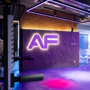 sala fitness futuristica con logo af al neon