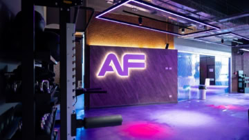 sala fitness futuristica con logo af al neon