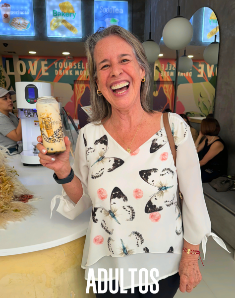 mujer sonriente con bebida en cafetería moderna