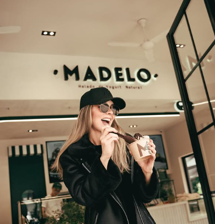 mujer sonriente con helado en tienda moderna