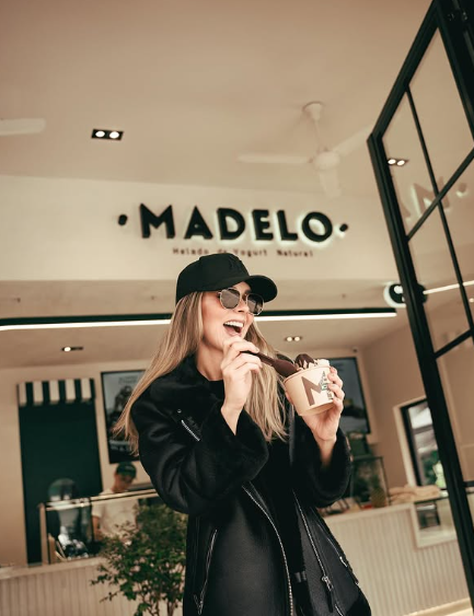 mujer sonriente con helado en tienda moderna