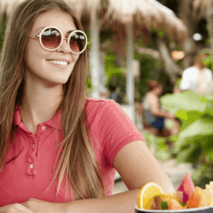 mujer sonriente con smoothie tropical y frutas