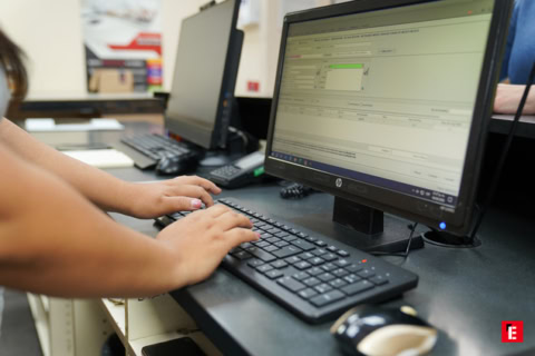 escritura en teclado frente a monitor de oficina