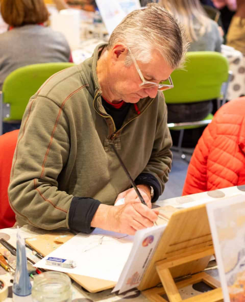 older man sketching in art workshop