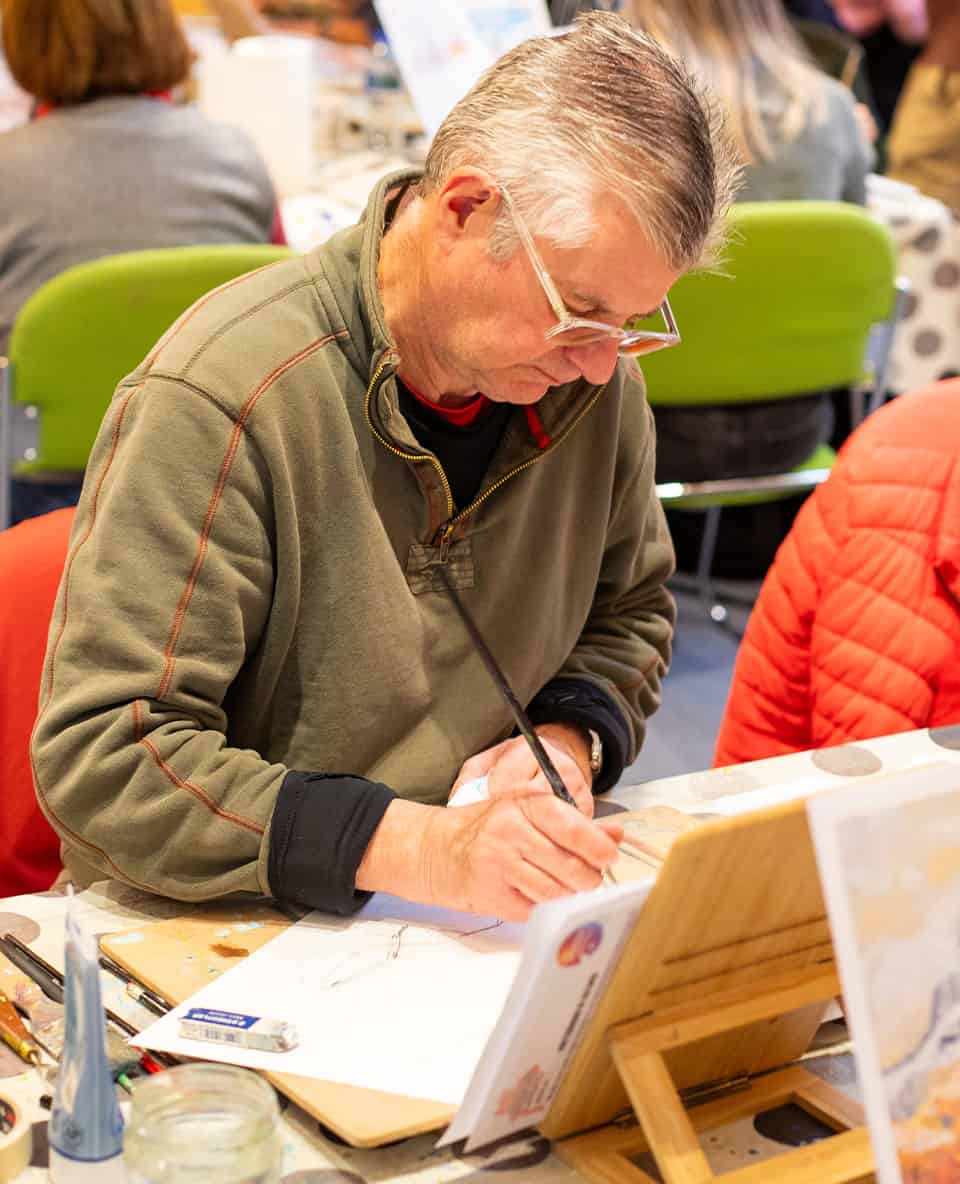 older man sketching in art workshop