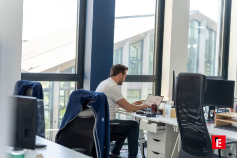homme travaillant sur ordinateur dans un bureau lumineux