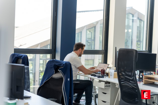 homme travaillant sur ordinateur dans un bureau lumineux