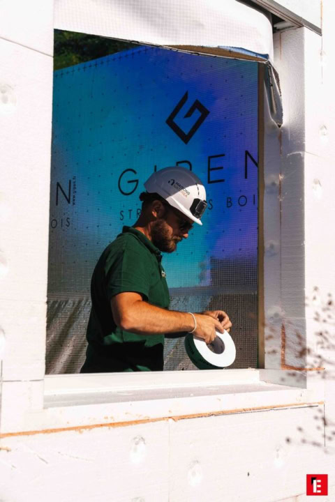 ouvrier sur le chantier : ruban adhésif et bâche bleue