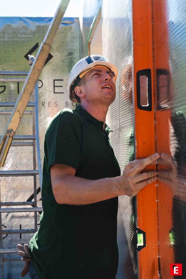 ouvrier utilisant un niveau à bulle sur chantier