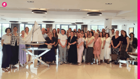 photo de groupe conviviale avec maquette de voilier