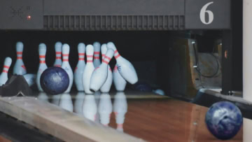 impatto al bowling: birilli, palla viola e riflessi