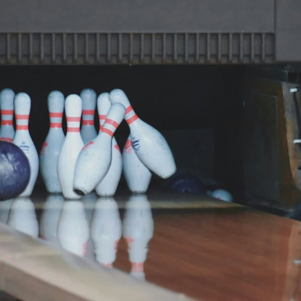 impatto al bowling: birilli, palla viola e riflessi