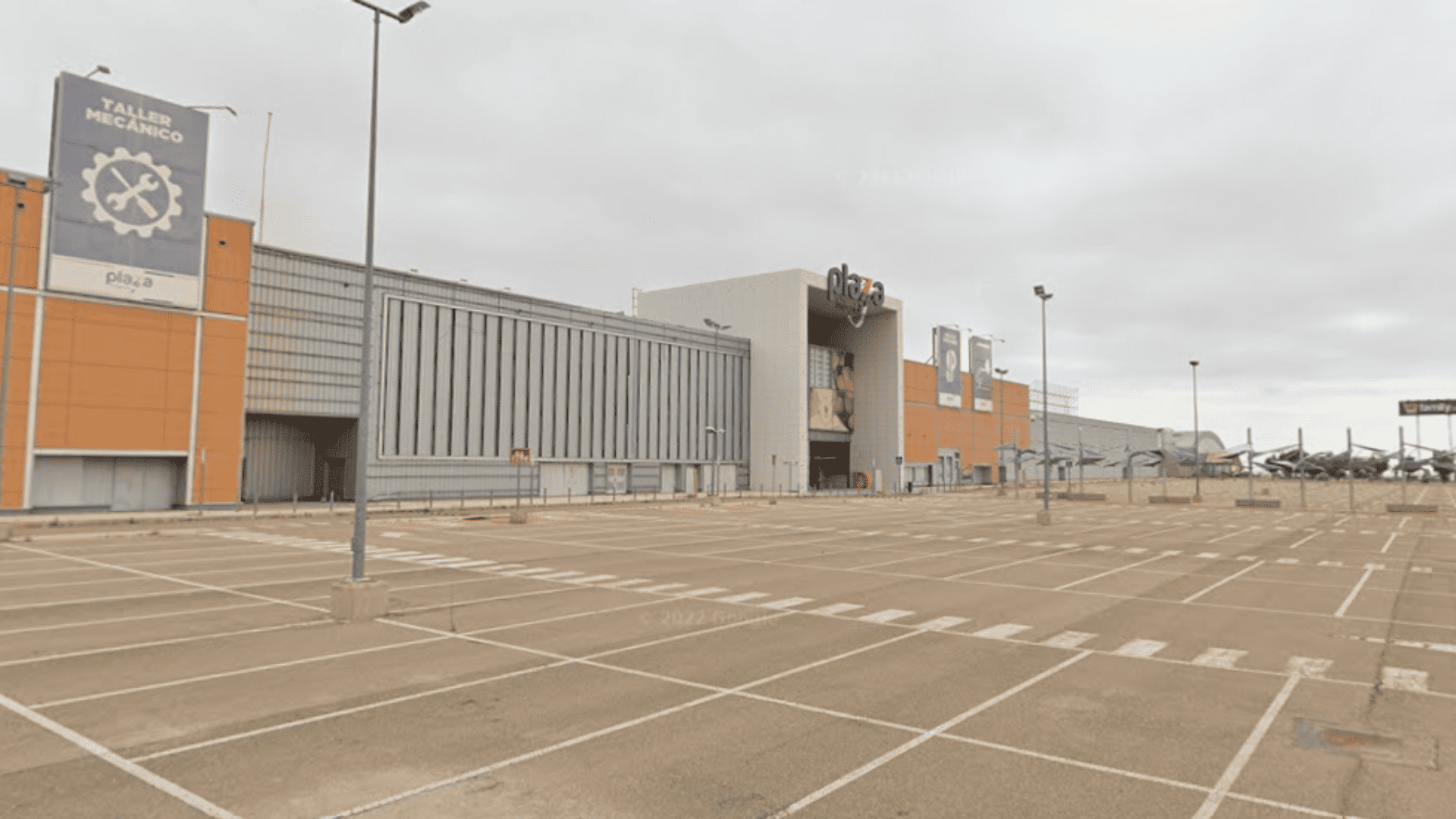 plaza comercial con taller mecánico y aparcamiento vacío