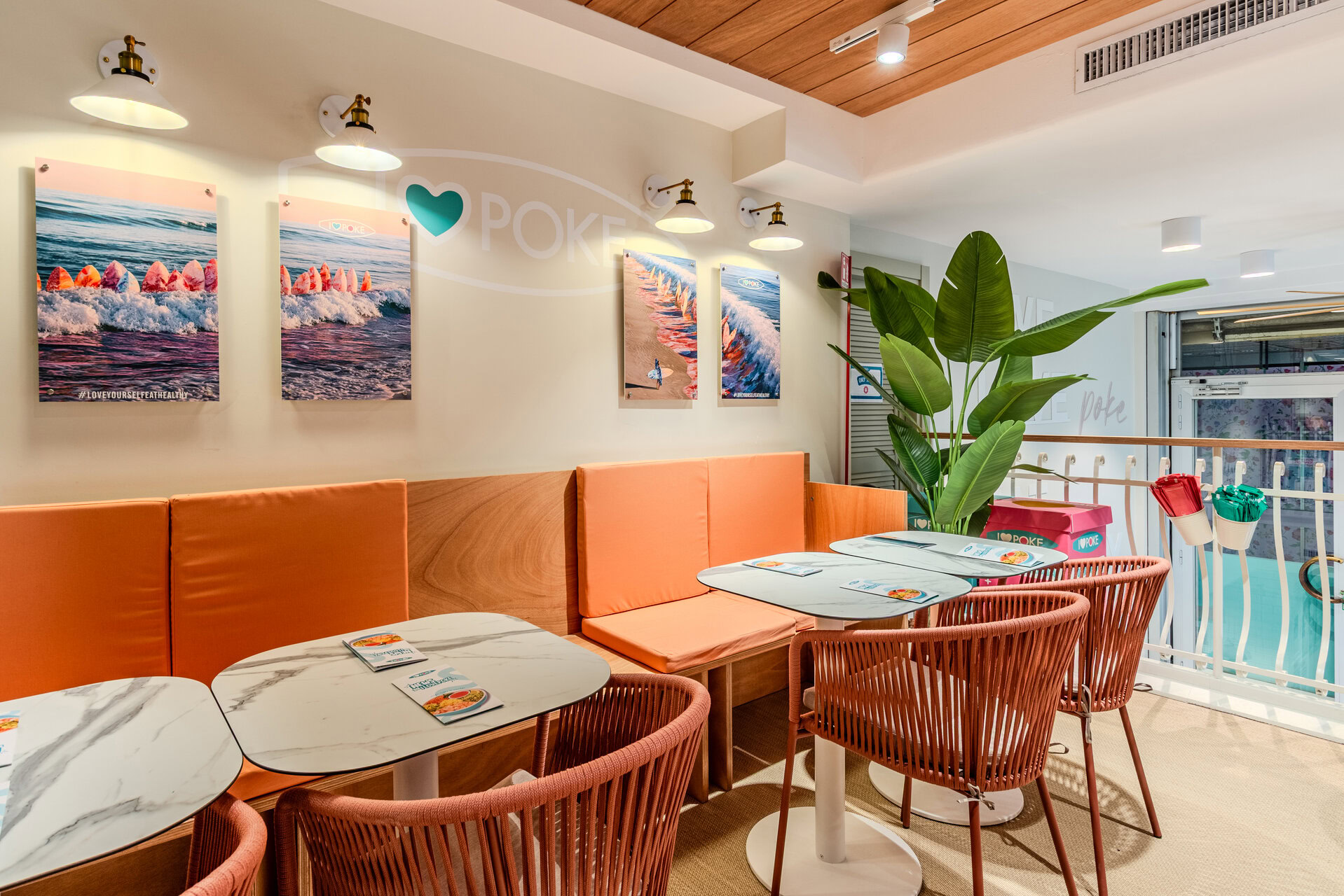 poke caffè moderno con banquette corallo e quadri surf