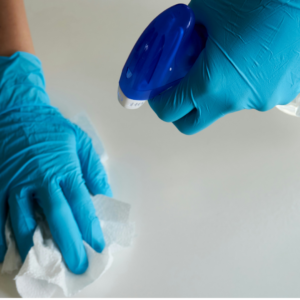 desinfektion mit blauen handschuhen und spray