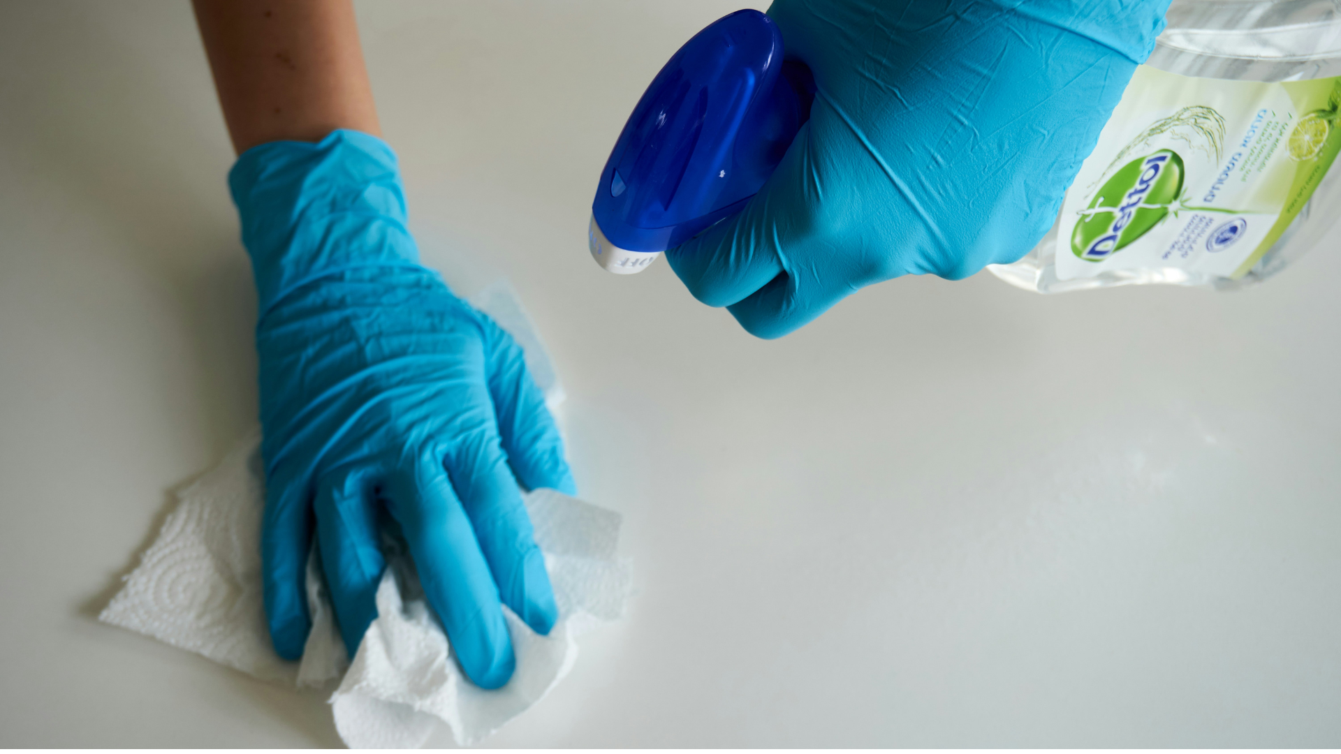 desinfektion mit blauen handschuhen und spray