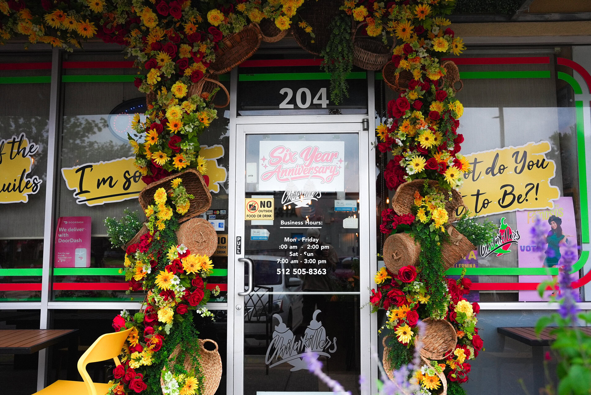 festive restaurant entrance with floral anniversary display