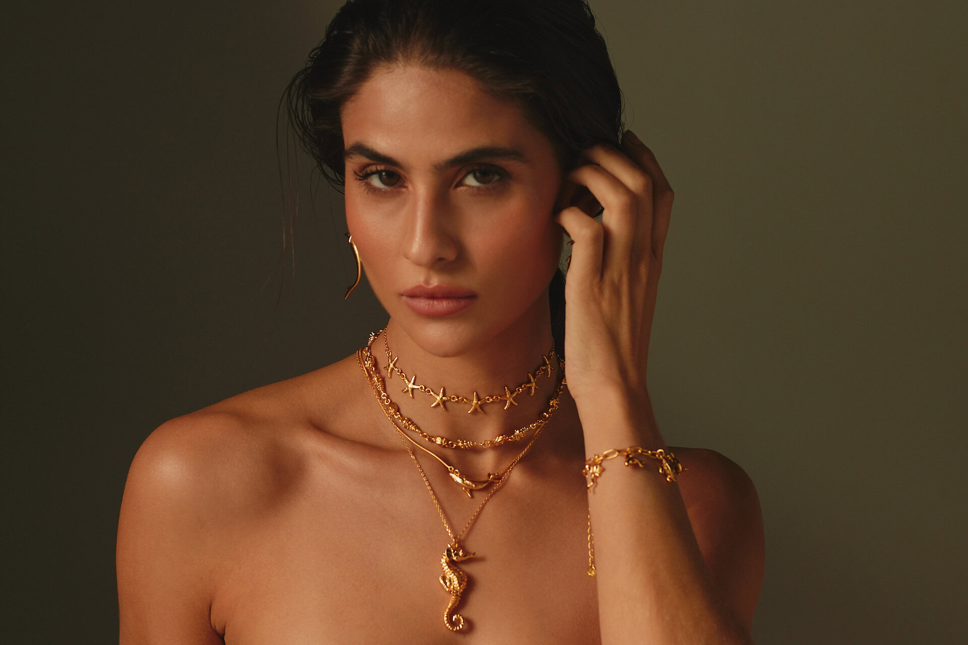 retrato Íntimo con joyas de oro y caballito de mar