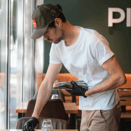 serveur prépare une table dans une pizzeria PizzaCosy