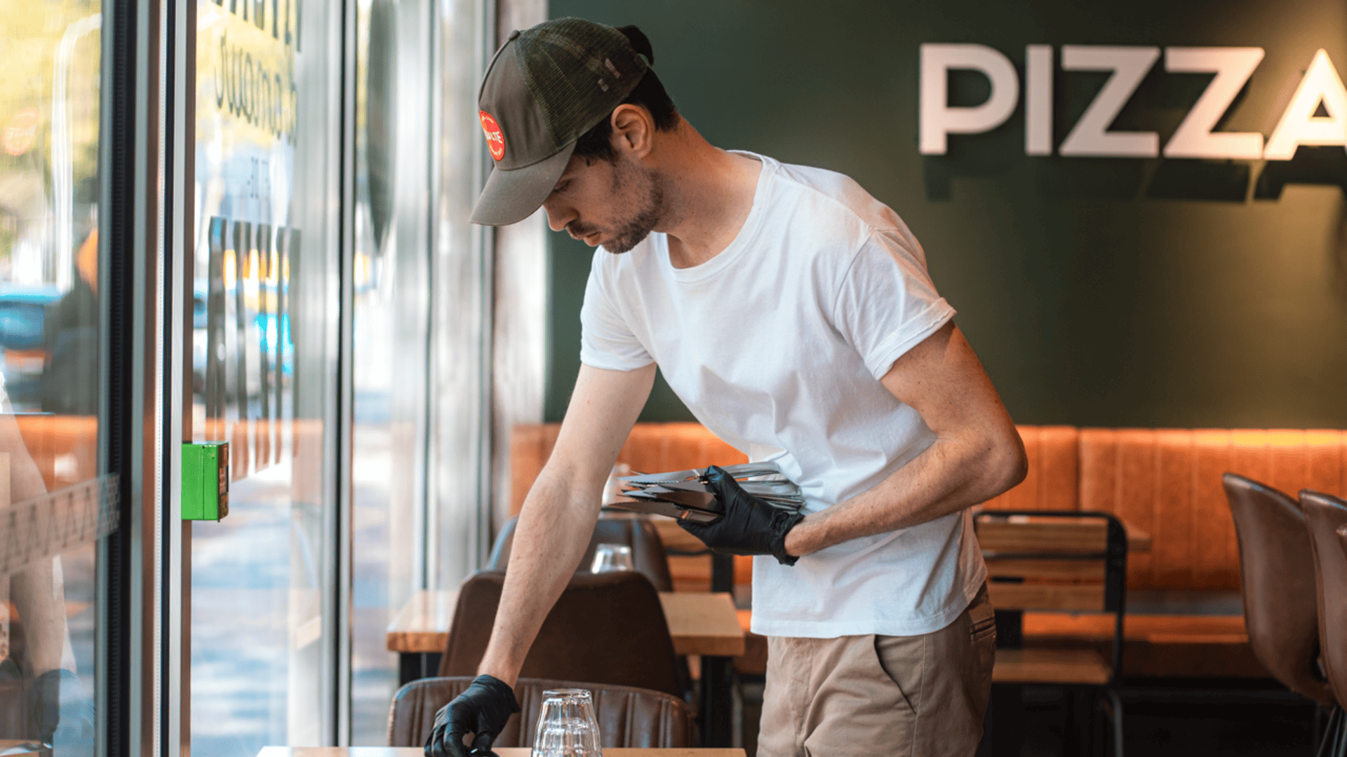 serveur prépare une table dans une pizzeria PizzaCosy