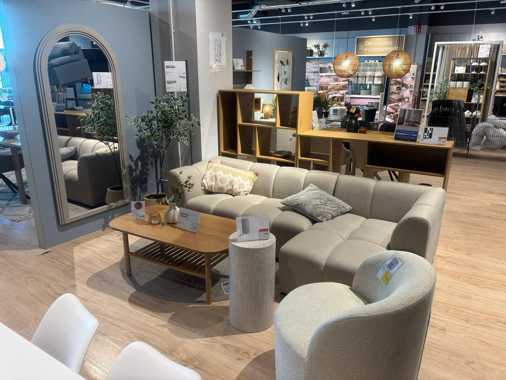 showroom arredo neutro: divano grigio e rattan