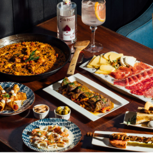 luxuriöses spanisches tapas festmahl mit paella und gin cocktails