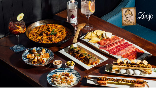 luxuriöses spanisches tapas festmahl mit paella und gin cocktails