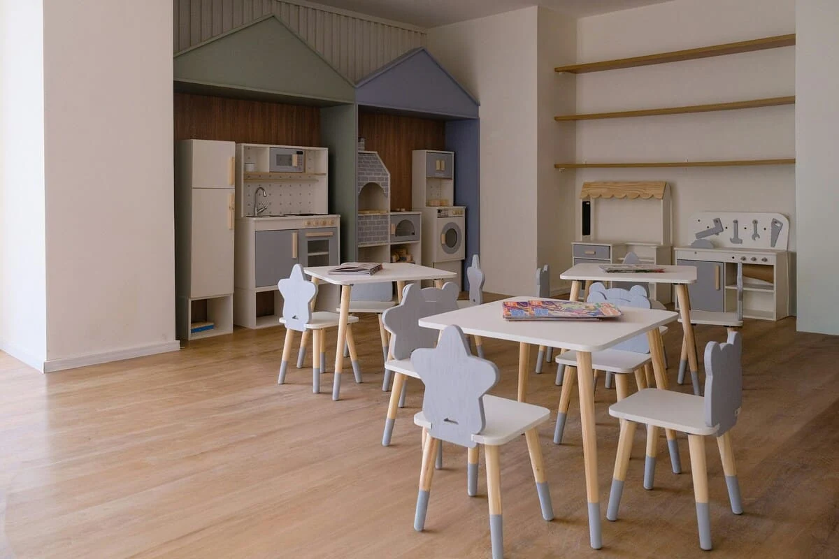 asilo minimalista con cucine giocattolo e tavoli