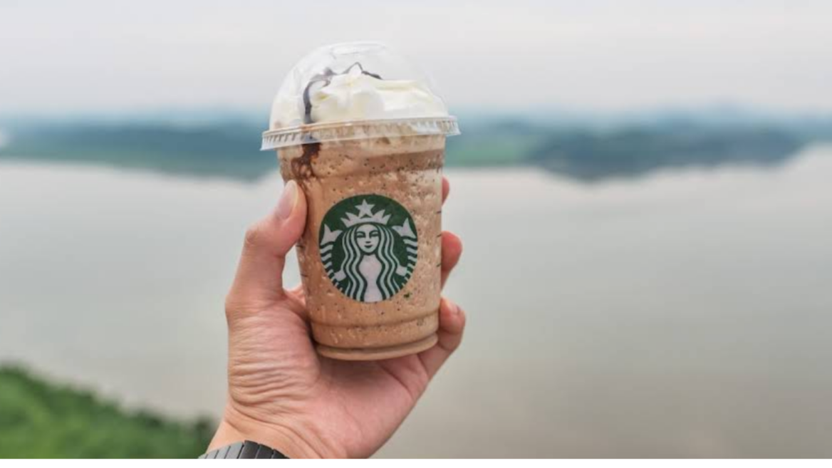 starbucks frappuccino in der hand am meer