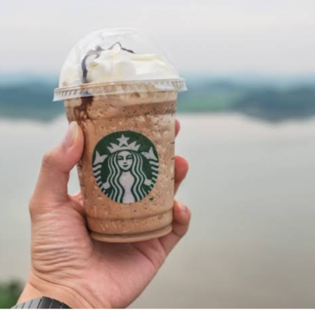 starbucks frappuccino in der hand am meer