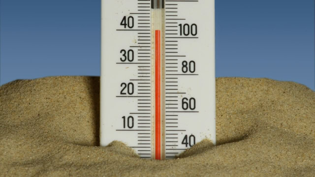 termometro nella sabbia: caldo estivo in spiaggia