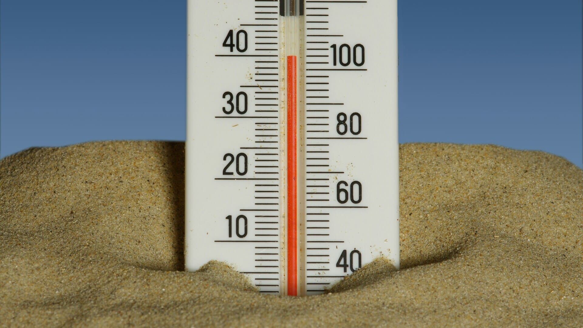 termometro nella sabbia: caldo estivo in spiaggia