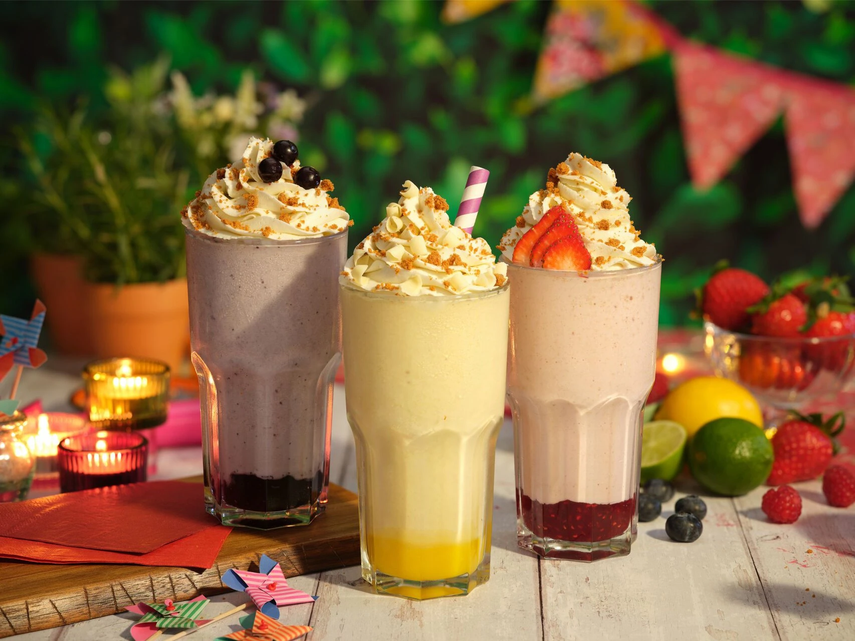 three frosty milkshakes with fresh berries