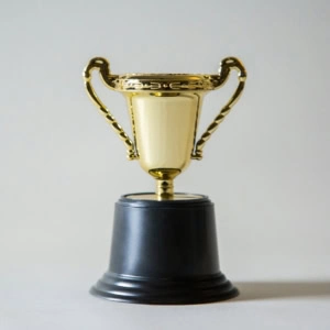 petit trophée doré minimaliste sur socle noir