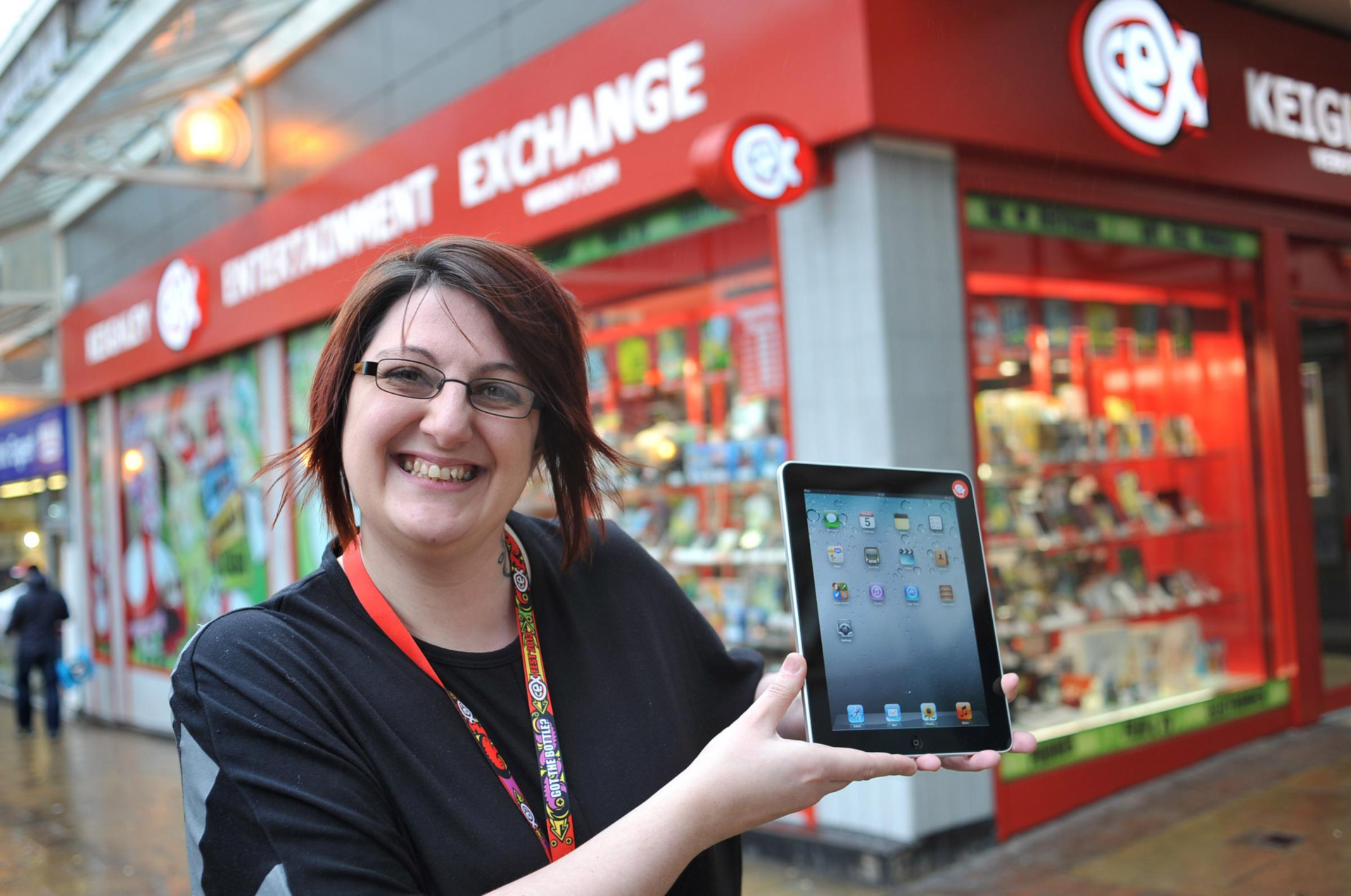 smiling woman showcases ipad at game exchange