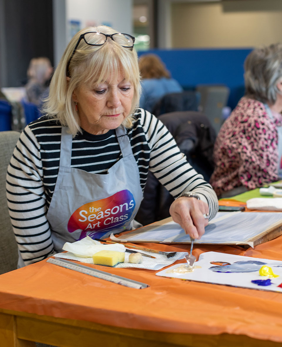 senior artist mixing paint with palette knife